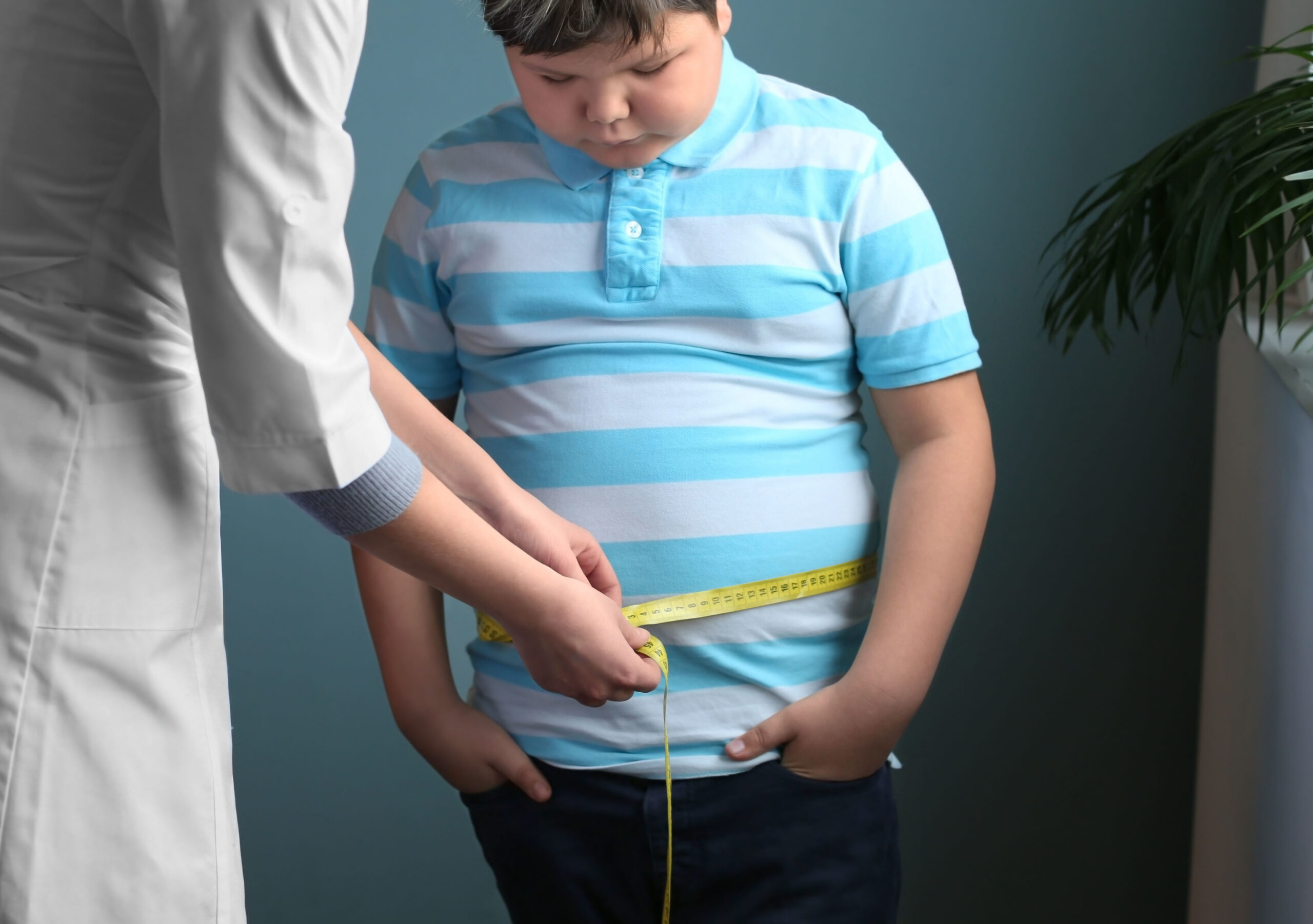 Doctor measuring overweight boy in clinic